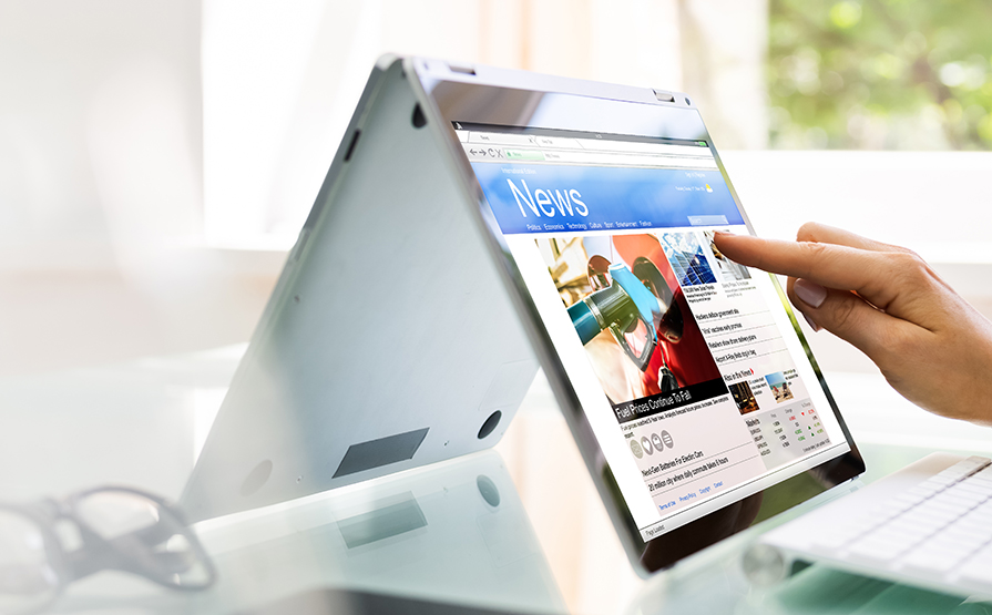 Closeup view of finger pointing at a news website on a tablet computer screen 