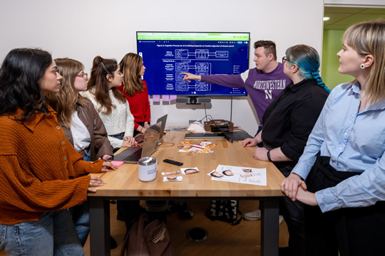 students around a table collaborating on a project
